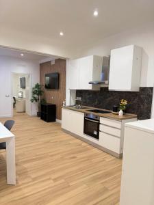 a kitchen with white cabinets and a wooden floor at NAVONA MORGAN suite in Rome