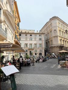 a group of people sitting at tables in a city street at NAVONA MORGAN suite in Rome