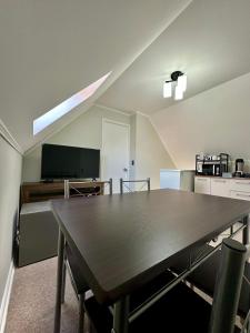 a dining room with a table and a tv at Latitud Guesthouse in Puerto Montt +24 photos