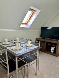 a dining room with a table and a television at Latitud Guesthouse in Puerto Montt