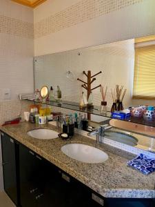 a bathroom counter with two sinks and a mirror at Duplex 301C | Alter do Chão in Alter do Chao