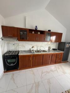 a kitchen with wooden cabinets and a sink and a stove at MeloMar Rooms in Ponta do Sol