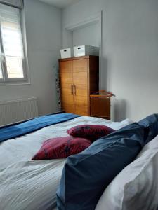 a bedroom with a bed with two pillows on it at The Clubhouse -Hypercentre Epernay in Épernay