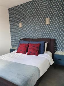 a bedroom with a bed with red and blue pillows at The Clubhouse -Hypercentre Epernay in Épernay