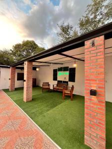an outdoor patio with a bench and grass at La Cautiva, Casa de descanso in Paraguarí