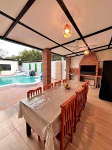 a dining room with a table and chairs and a pool at La Cautiva, Casa de descanso in Paraguarí