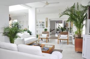 una sala de estar con muebles blancos y macetas. en Penthouse Caribbean View and private pool, Cartagena, en Cartagena de Indias