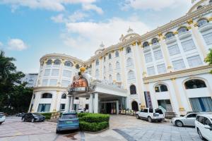 広州市にある广州维福顿白宫酒店の大きな白い建物とその前に駐車された車