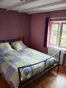 a bedroom with a bed with a colorful comforter at La petite lisonne in Marval