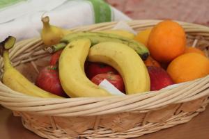 a basket of fruit with bananas apples and oranges at Rivotorto Retreat House in Birkirkara