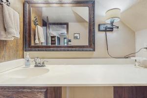un baño con lavabo y espejo en Clutter Falls Retreat - Main House, en Gruene 32 fotos más