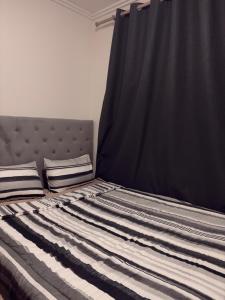 a bedroom with a bed with a black curtain at Heavenly Home in Cape Town