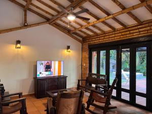 a living room with a tv and a table and chairs at Casa Panaca Portal 12 in Quimbaya