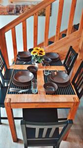 a wooden table with plates and flowers on it at Joana in Gelnhausen +10 photos