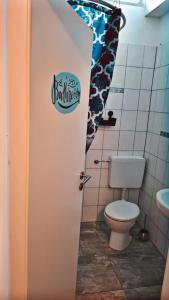 a bathroom with a toilet and a door with a sign on it at Joana in Gelnhausen