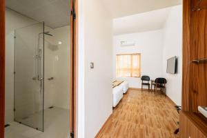 1 dormitorio y baño con ducha acristalada. en Phoenix Mộc Châu Resort, en Mộc Châu