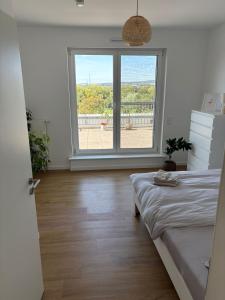 a bedroom with a bed and a large window at Apartment in Giessen mit Wetblick in Gießen