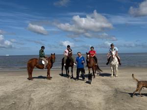 a group of people riding horses on the beach at Casa en el campo in Montevideo
