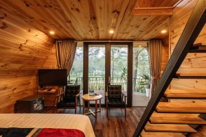 a bedroom in a log cabin with a bed and a television at Phoenix Mộc Châu Resort in Mộc Châu
