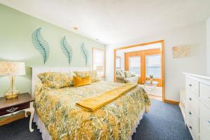 Un dormitorio con una cama con una colcha amarilla. en Sea Sun Greetings, en Kitty Hawk 108 fotos más