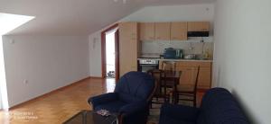 a living room with two chairs and a kitchen at DDS-Niš in Niš