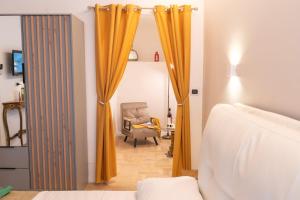a bedroom with an orange curtain and a chair at Celestino V in Sulmona