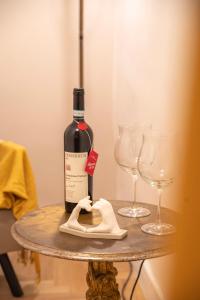 a bottle of wine on a table with two glasses at Celestino V in Sulmona