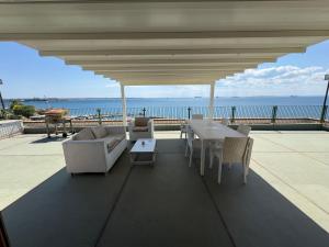 a patio with a table and chairs and the ocean at La Suite del Mare in Taranto