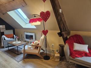 Una sala de estar con corazones colgando del techo. en Appart Cosy avec SPA privatif proximité Lille, Le Chalet, en La Bassée