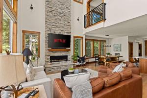 ein Wohnzimmer mit Couch und Kamin in der Unterkunft 2 Homes Sleeps 22 Sauna Hot Tub Fire Pit in Government Camp