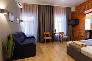 a hotel room with a bed and a couch and a table at Нова квартира в центрі на Харківській набережній 3-4 in Kharkiv