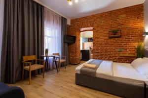 a hotel room with a bed and a brick wall at Нова квартира в центрі на Харківській набережній 3-4 in Kharkiv