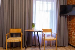 a table and two chairs in a room with a window at Нова квартира в центрі на Харківській набережній 3-4 in Kharkiv +7 photos