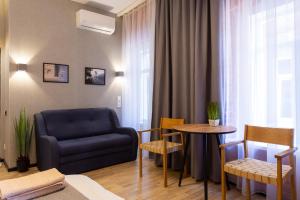 a living room with a blue couch and a table at Нова квартира в центрі на Харківській набережній 3-4 in Kharkiv
