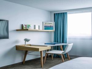ein Schreibtisch und ein Stuhl in einem Zimmer in der Unterkunft Mercure Vannes Le Port in Vannes + 114 Fotos