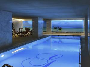 a swimming pool in a house with a view of the ocean at Sofitel Beirut Le Gabriel in Beirut