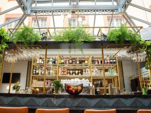 蒙托邦Hôtel Mercure Montauban的天花板上种有植物的建筑物内的酒吧