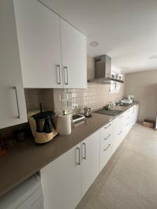 a kitchen with white cabinets and a counter top at Isla Sicilia in Oliva +11 photos