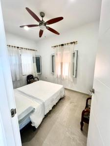 a bedroom with a bed and a ceiling fan at Isla Sicilia in Oliva
