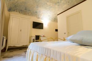 a bedroom with a bed and a tv on a wall at Palazzo Tasca in Noto