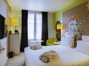 a hotel room with a large bed with two bags on it at Mercure Nice Centre Grimaldi in Nice