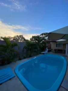una grande piscina blu su un patio di Tolentino - Casa de Praia a Santa Cruz Cabrália