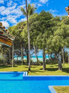 a resort swimming pool with a view of the ocean at Paraíso Casa Branca in Arraial d'Ajuda