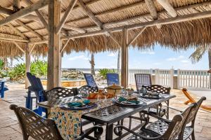 une table à manger et des chaises sur une terrasse avec la plage dans l'établissement Gulf Front Dreams, à Clearwater Beach