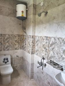 a bathroom with a shower and a toilet and a sink at Tranquill Homestay in Tirupati
