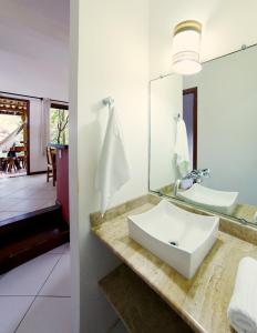 y baño con lavabo y espejo. en Manacá Flat, en Itacaré