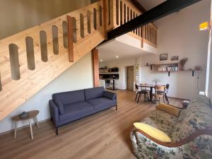 Una sala de estar con un sofá y una escalera. en Auberge de Boffres, en Boffres
