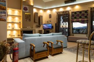 Una sala de estar con un sofá azul y dos sillas. en The Sunset Haven Kastoria - Modern Lake Elegance, en Kastoria