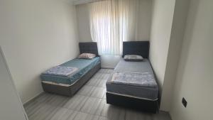 two beds in a small room with a window at Köşk Rezidans Apart in Aksaray