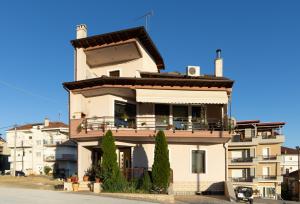 Un gran edificio blanco con balcón. en The Sunset Haven Kastoria - Modern Lake Elegance, en Kastoria